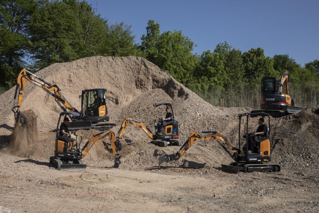 Kilka minikoparek CASE serii CX, pracujących równocześnie na placu budowy – na tle hałd żwiru i ziemi